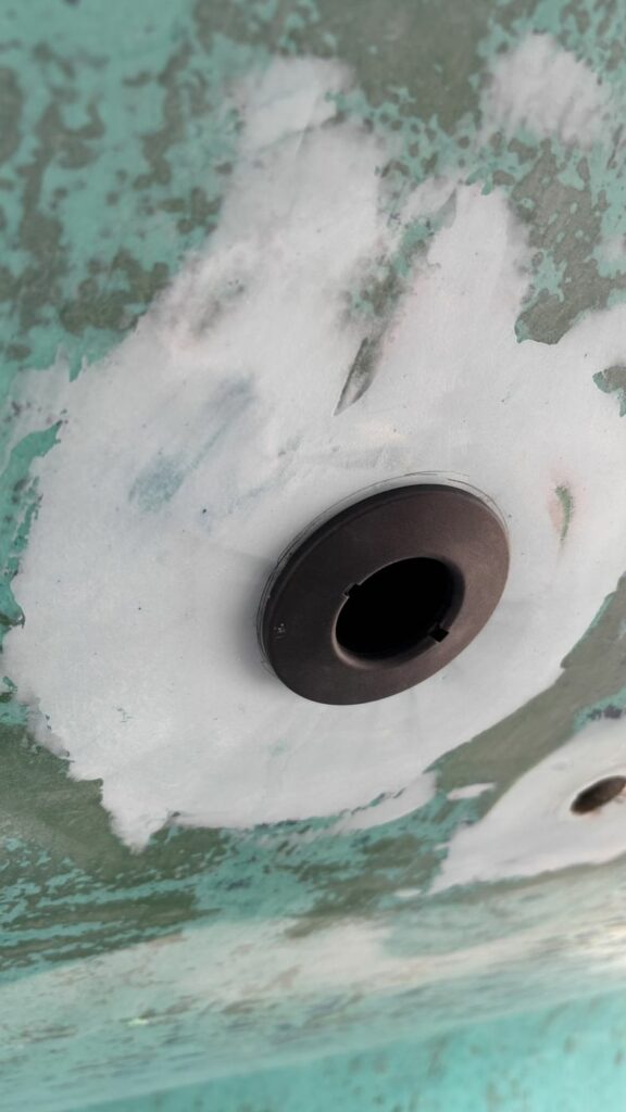 Passe-coque composite posé, le mastic ayant flué tout autour de la collerette